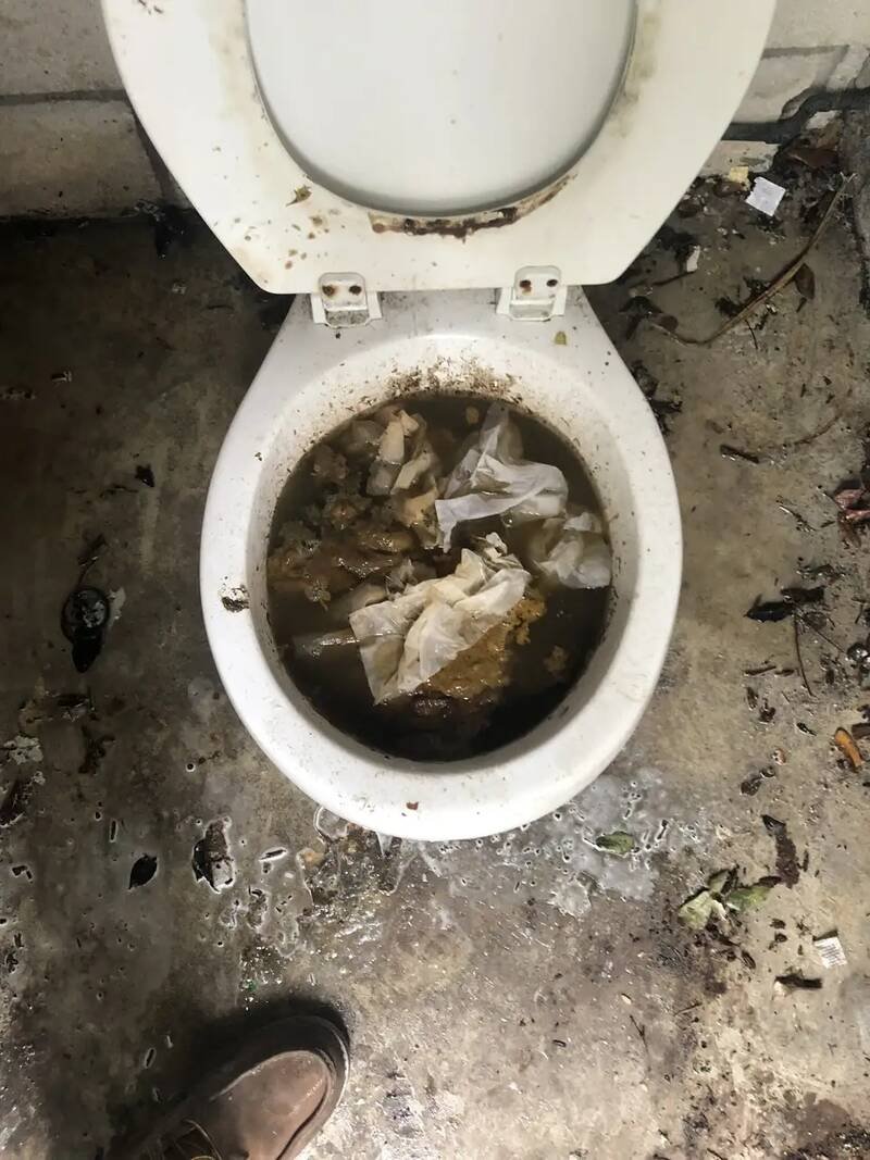 Clogged toilet bowl full of paper and waste, before the line was cleared