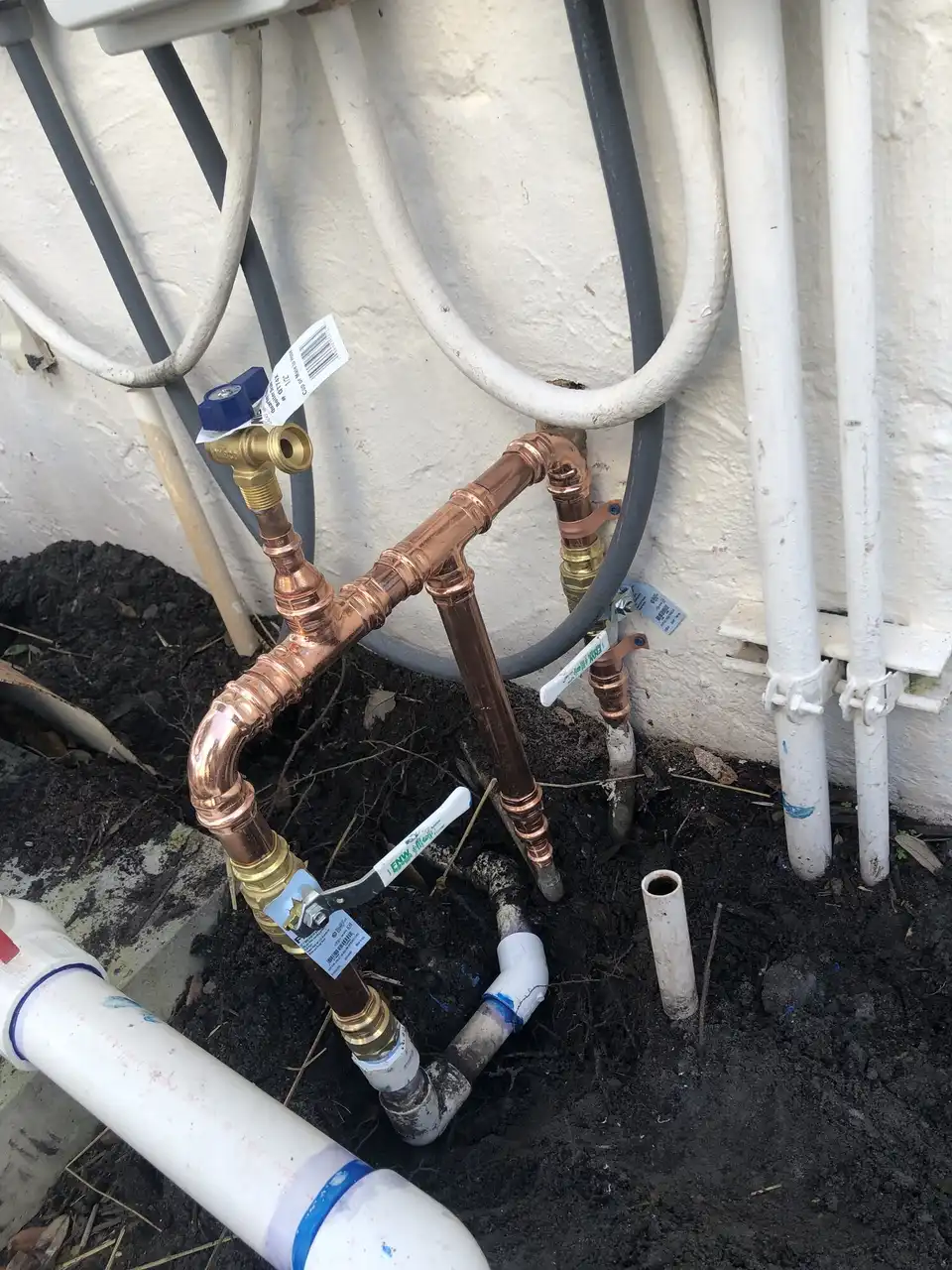 New copper water line with shutoff valves plumbed on the outside wall of a home