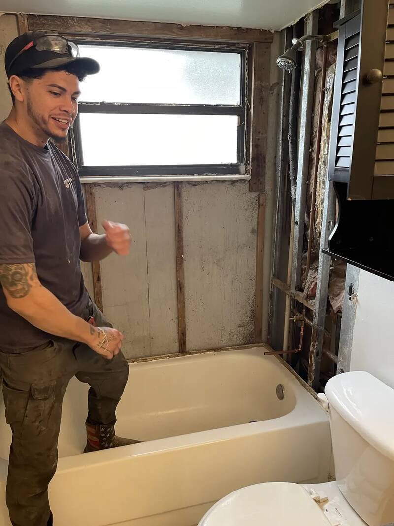 Drain Masters plumber in a gutted bathroom with the wall plumbing opened up