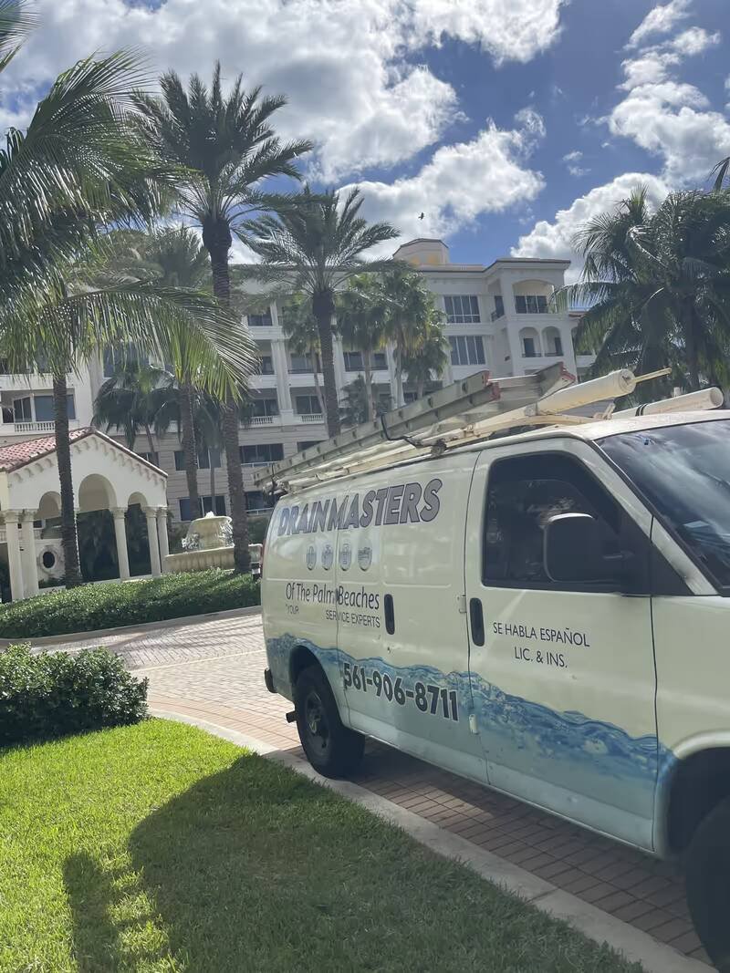 Drain Masters of the Palm Beaches service van parked outside a customer's building