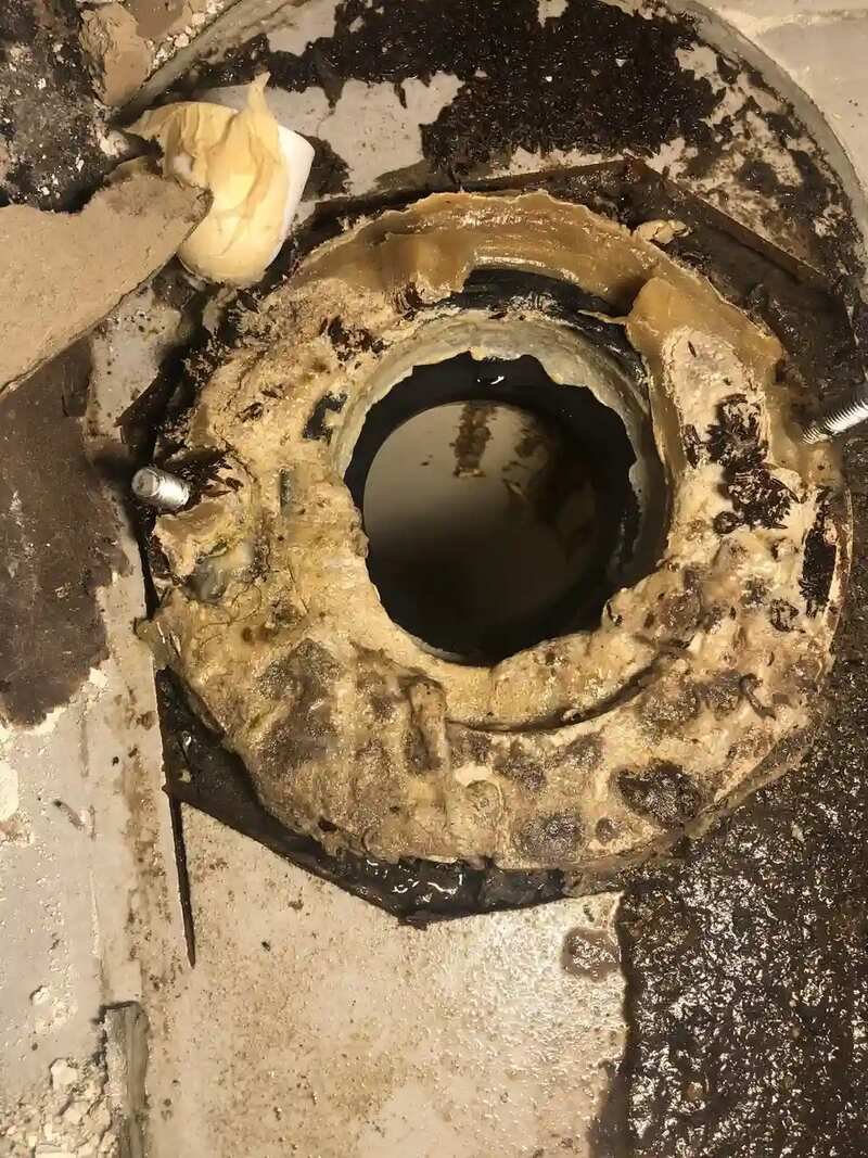 Toilet pulled to expose the closet flange and drain opening for repair